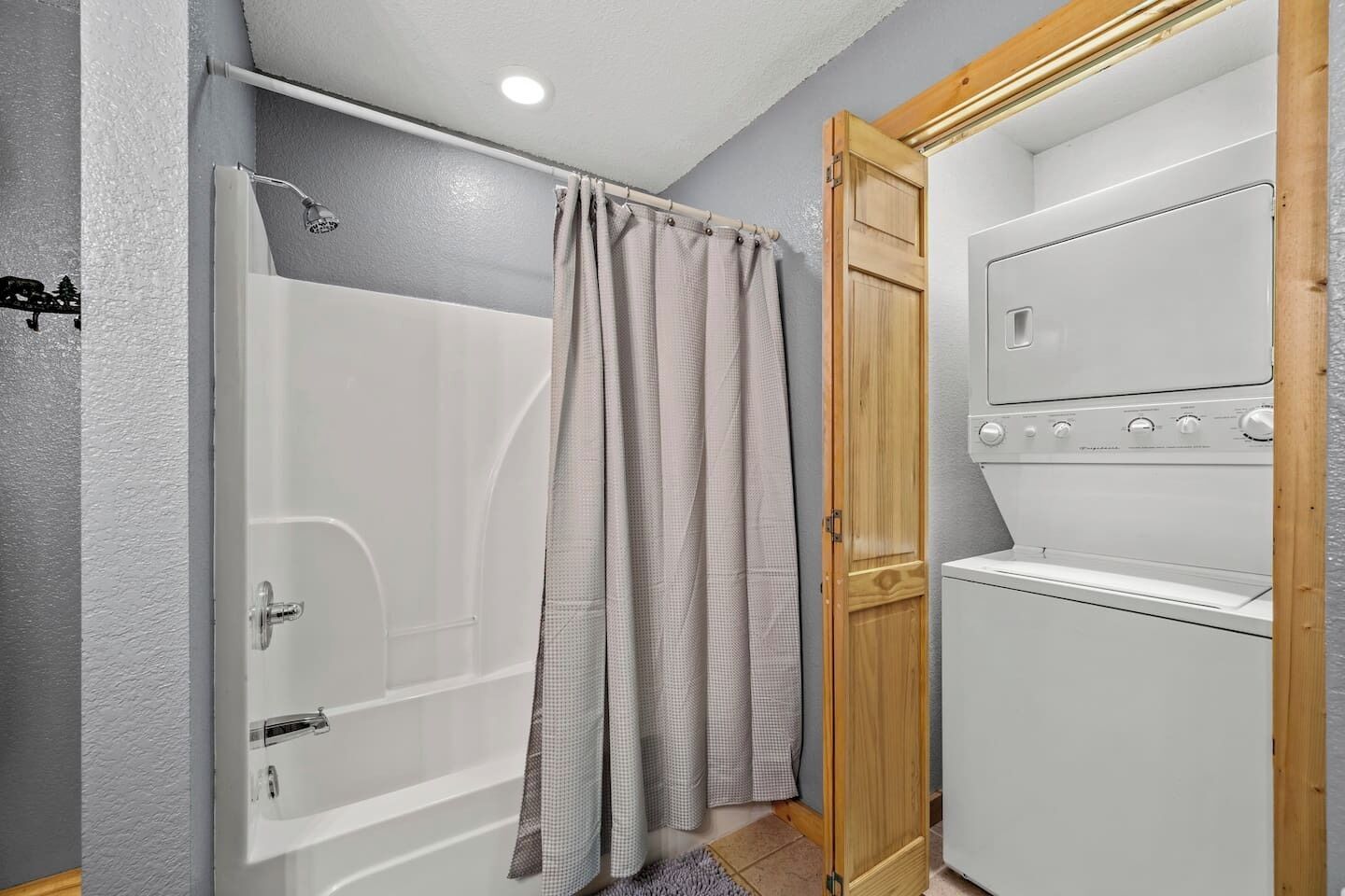Ein Badezimmer mit Dusche, Toilette und Waschmaschine.