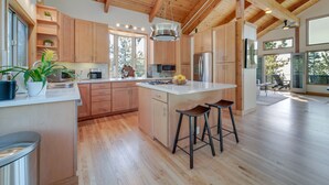 Una cocina moderna con armarios de madera, una isla central y taburetes de bar.