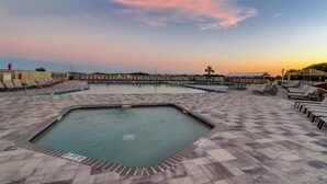 Un área de piscina con varias piscinas y sillas de descanso.