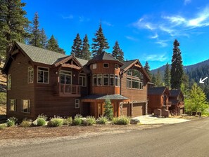 Heavenly's Boulder Lodge, a large wooden building with multiple windows and a balcony, surrounded by trees and mountains.