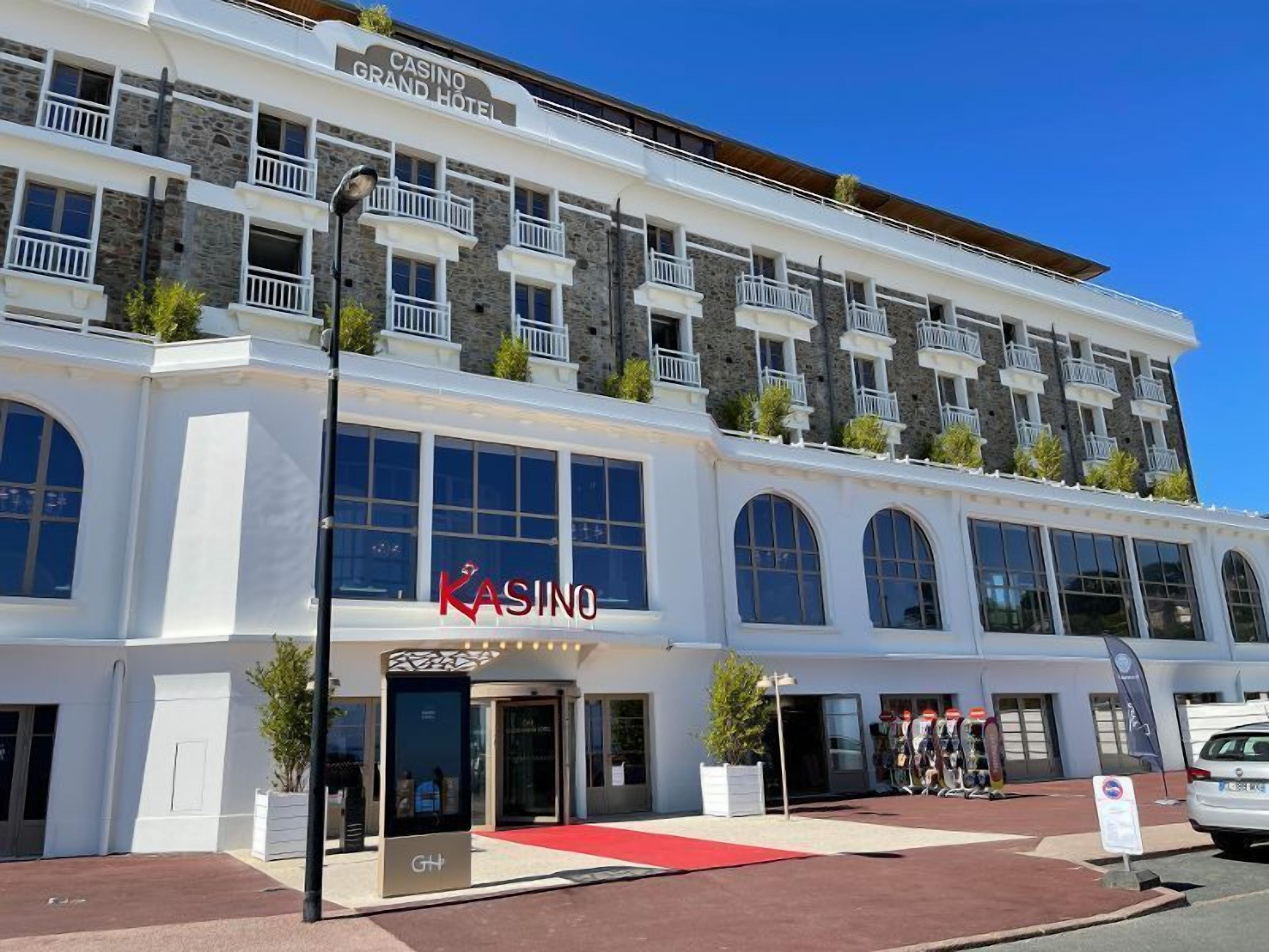 A multi-story building with a casino sign, large windows, and a red carpet entrance.
