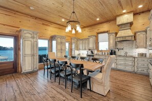 Une cuisine spacieuse avec des meubles en bois, un grand îlot central et une vue sur le lac.