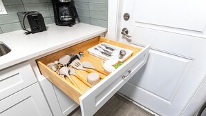 A kitchen with a drawer containing utensils, a toaster, and a coffee maker. - Family-friendly 2-bed, 2-bath ground-floor unit in Indian Rocks Beach. Sleeps eight with full kitchen, WiFi, smart TV, beach gear, and direct pool access. A comfortable, convenient base for sand days, sunsets, and easy coastal living (Indian Rocks Beach)