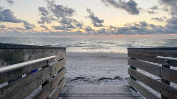 A wooden boardwalk leading to a beach with a cloudy sky. - MySunsetView 6 Unit3 Studio+Pool 3min to Beach (Indian Rocks Beach)