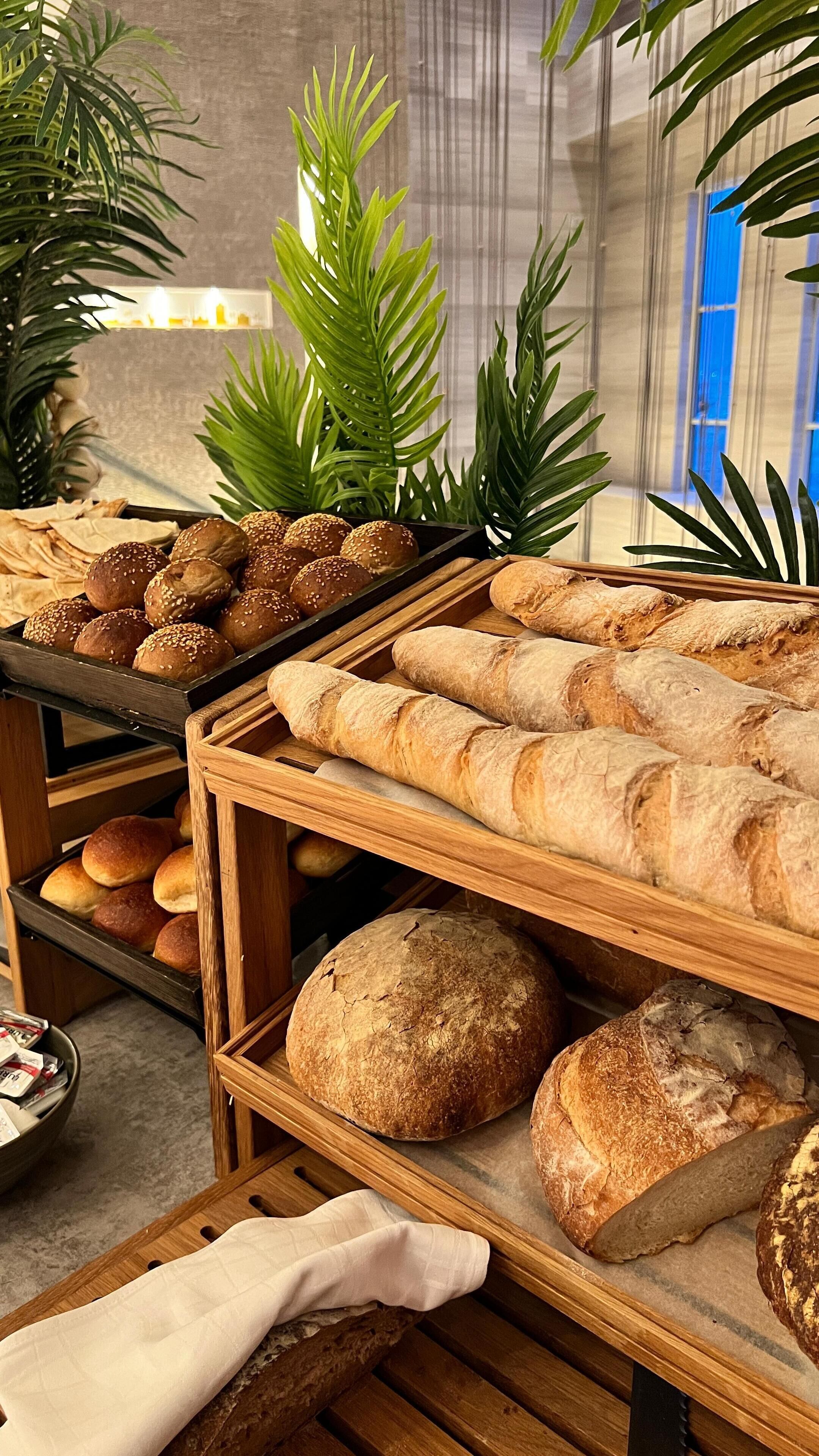 Mostrador de panadería con panes y pasteles varios.