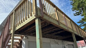 A residential building with a wooden deck and garage. - Spacious 2-bed, 2-bath second-floor unit near Indian Rocks Beach. Sleeps eight with full kitchen, WiFi, smart TV, shared pool access, and beach gear. A bright, comfortable base for families and groups looking for easy sand days and sunset evenings. (Indian Rocks Beach)