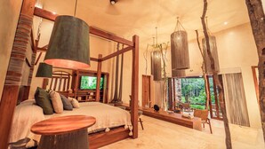Une chambre spacieuse avec un grand lit, une tête de lit en bois, une télévision et une vue sur l’extérieur.
