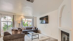 A living room with a sofa, armchairs, a coffee table, a TV, and a fireplace. - 1 Block to Pacific Beach/FOOD/Bars, Updated, 2-Car Garage w/fee, Yard, Sleeps 12 (San Diego)
