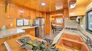 A compact kitchen with wooden cabinets, a stainless steel refrigerator, and a sink. - Hot Tub & Deck: Waterfront Escape in Payson! (Payson)