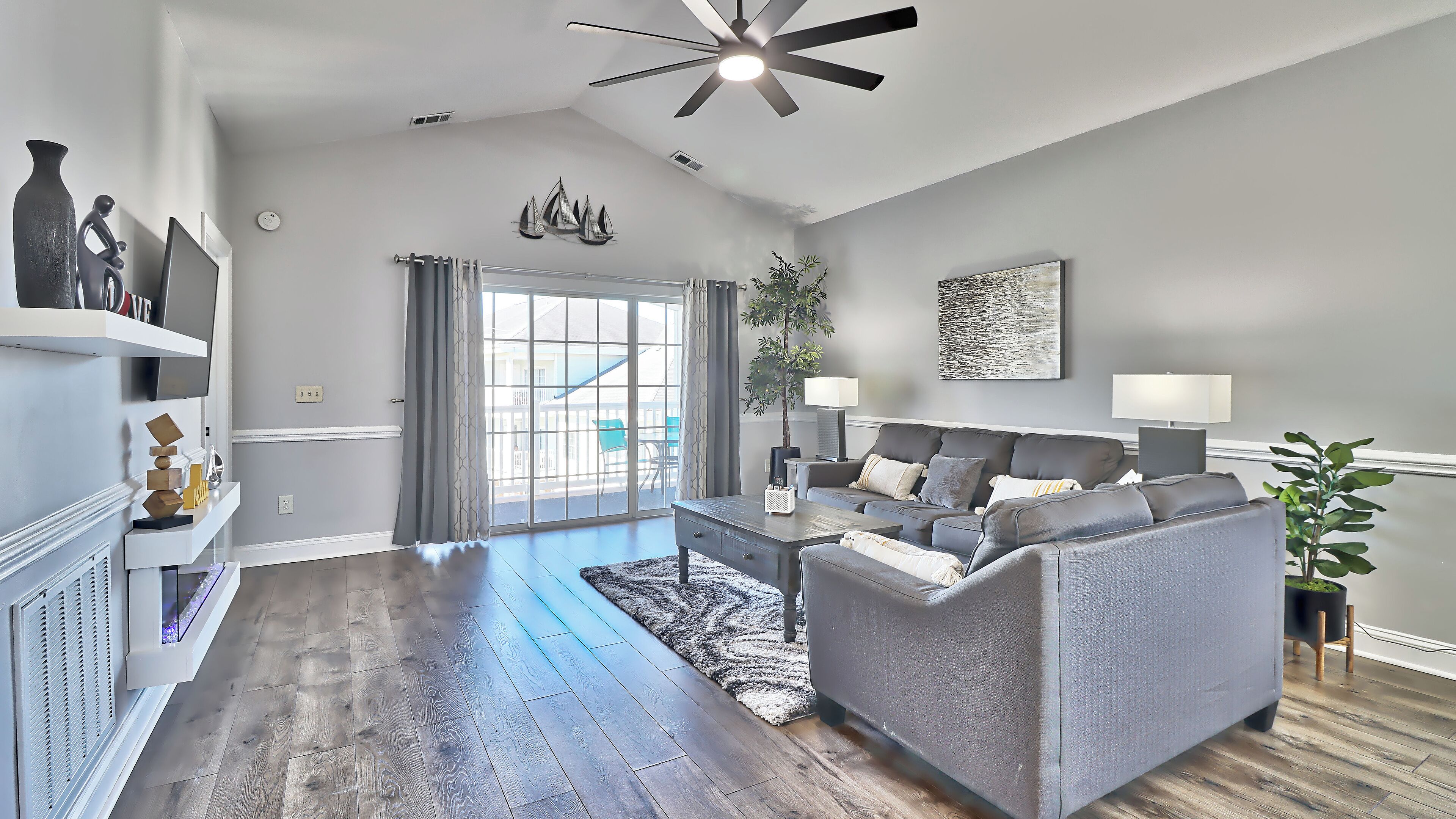 A modern living room with a grey sofa, a coffee table, and a fireplace.