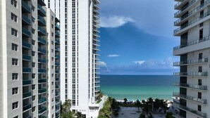 Un hôtel de grande hauteur doté de nombreux balcons donnant sur une plage et une piscine.