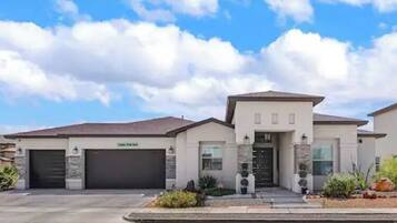 Stunning residential building with a central entrance, garage doors, and beautifully landscaped grounds.