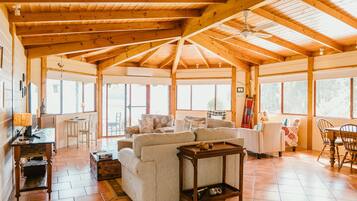 Cozy cabin-style accommodation with a high ceiling, seating area, and kitchenette.