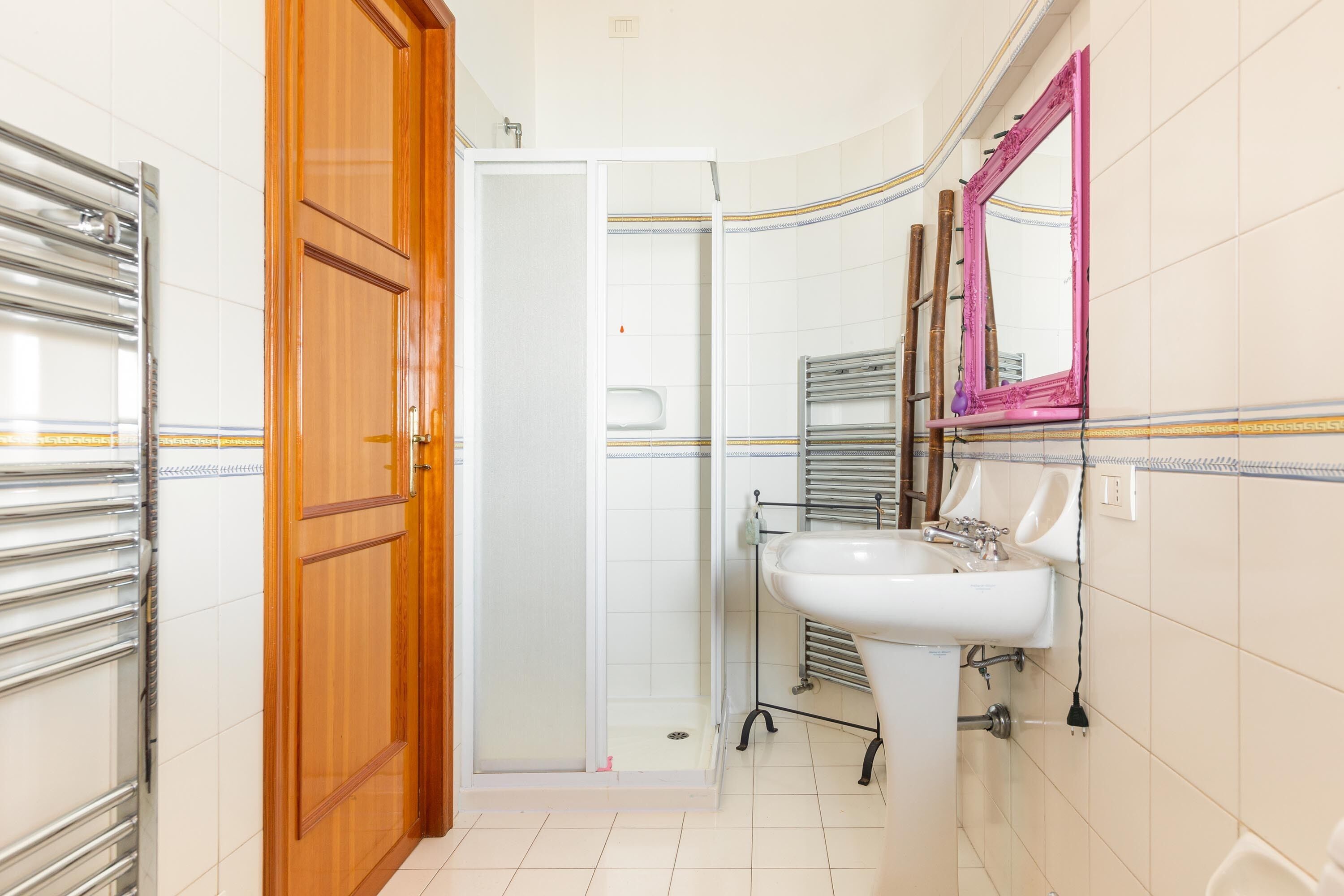 Ein Badezimmer mit Dusche, Waschbecken und Spiegel.