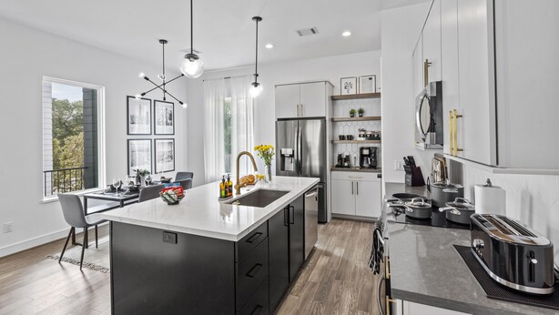 A modern kitchen with a central island, stainless steel appliances, and pendant lighting. - Modern Townhome near Galleria - Garage Gym / Private Backyard (Houston)