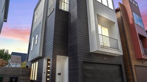A modern two-story residential building with a garage, a balcony, and a visible address number. - Modern Townhome near Galleria - Garage Gym / Private Backyard (Houston)