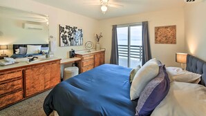 Habitación de hotel con cama, escritorio, cómoda, espejo y vistas al exterior.