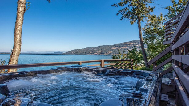 Tinaco con vista a un lago pintoresco, terraza de madera y cielo azul brillante.