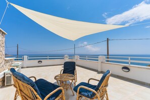 A balcony with wicker chairs and a table, overlooking the sea. - 2049 Casa Marchello - Bilo 3 by Barbarhouse (Castrignano del Capo)