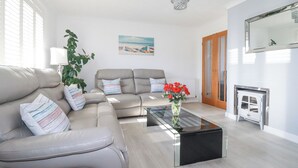Ein modernes Wohnzimmer mit einer Couch, einem Couchtisch und einem Bild an der Wand.