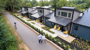 A modern residential complex with multiple houses featuring flat roofs, large windows, and outdoor seating areas. - Elevated, Boutique Space on the Swamp Rabbit Trail (Travelers Rest)