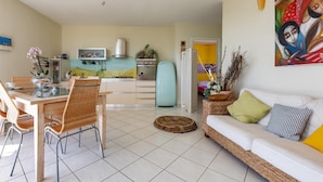 A modern living room with a dining area, a kitchen, and a colorful painting on the wall. - 2539 Casa di Isa by Barbarhouse (Castrignano del Capo)