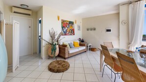 A living room with a sofa, coffee table, and dining table with chairs. - 2539 Casa di Isa by Barbarhouse (Castrignano del Capo)
