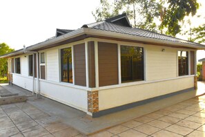 Situated in a suburban setting, this single-story home features a combination of siding and brickwork, with a flat roof and series of windows.