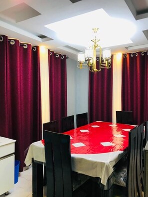 Enjoy meals in this stylish dining area with a rectangular table, chandelier, and comfortable black chairs.