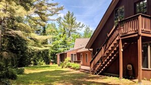Une cabane avec une façade en bois, une véranda et un escalier menant à l’entrée.
