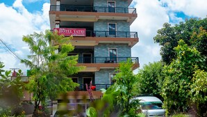 Un edificio de hotel de varios pisos con balcones y un letrero que dice "HOTEL YATRI".