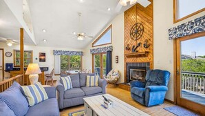 A spacious living area with a fireplace, large windows, and a balcony. - A Peace of Quiet | 1,025 ft. to the Beach | Private Pool (Duck)