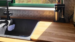 A kitchen with a sink, a window, and a view of trees and hills. - Theplatresnest Lovely 3-bed House in Pano Platres (Platres)
