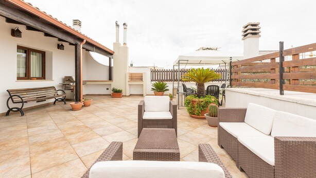 A rooftop patio with wicker furniture, potted plants, and a wooden fence. - 3125 Saturday`s House by Barbarhouse (Casarano)