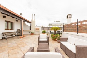 A rooftop patio with wicker furniture, potted plants, and a wooden fence. - 3125 Saturday`s House by Barbarhouse (Casarano)