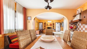 A dining area with a wooden table, wicker chairs, and a central decorative bowl. - 3125 Saturday`s House by Barbarhouse (Casarano)