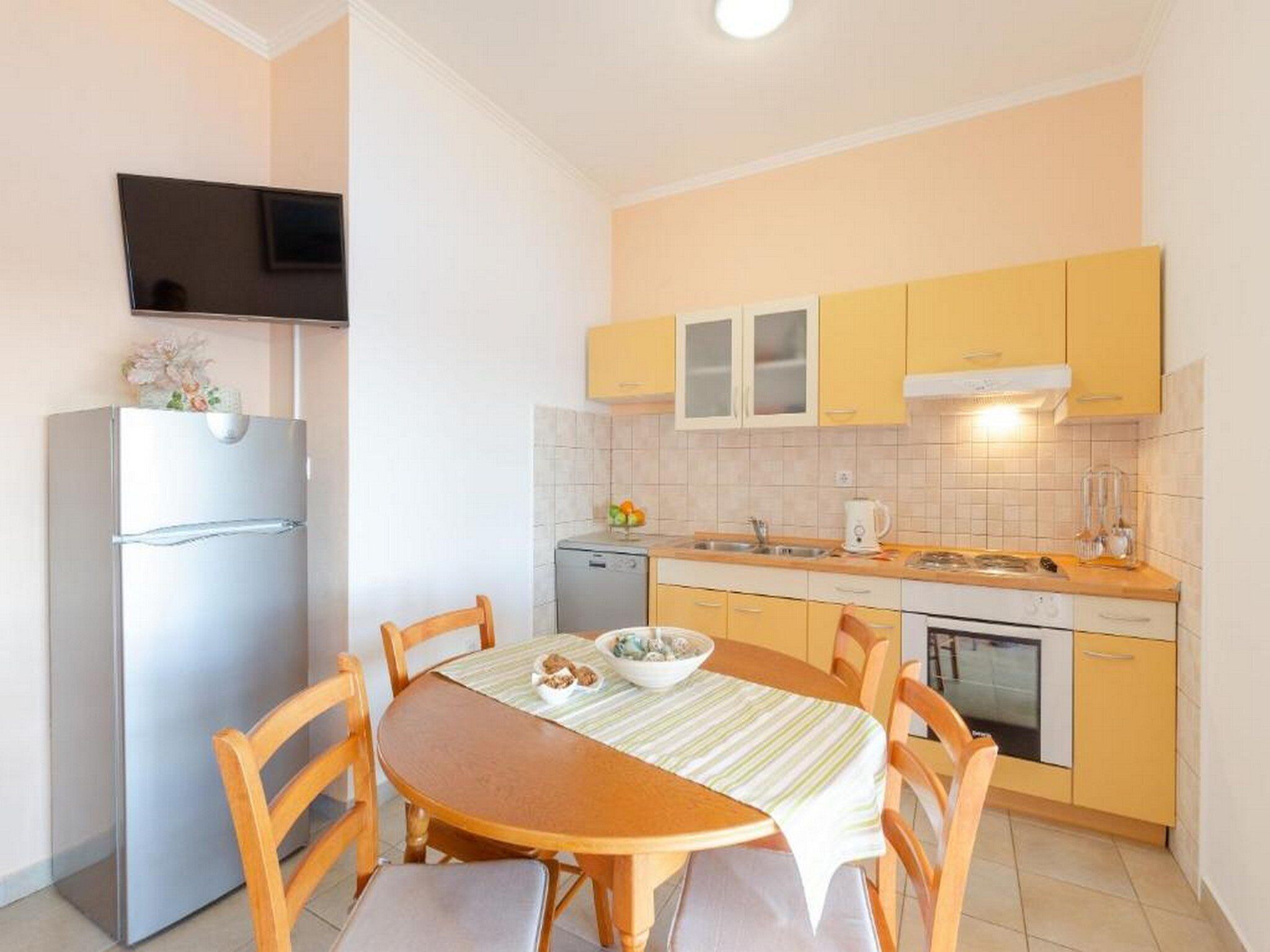 A compact kitchen with a dining table, chairs, a refrigerator, a microwave, and a stove.