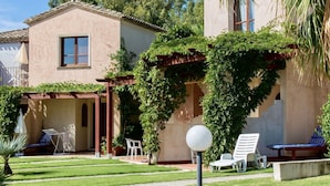 A house with a patio area, outdoor seating, and a well-maintained garden. - Studio apartment 2 beds, (20/25 mq): living room with kitchenette, table fridge and double or double bed, bathroom. <br>All studios are located <b>on the ground floor</b>.<br>All the flats have a view of the park. <br>The apartments are equipped with: <b (Pula)