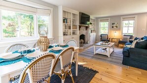 Ein Wohnzimmer mit Essbereich, Kamin und Bücherregal.