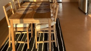 A modern kitchen with wooden cabinets, stainless steel appliances, and a dining area with a wooden table and chairs. - Stunning spacious suite with amazing views! (Halfmoon Bay)