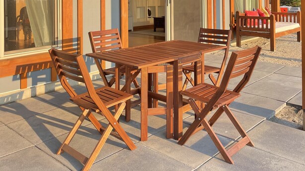 A covered patio with a wooden table and chairs, large sliding glass doors, and a view of the interior. - Stunning spacious suite with amazing views! (Halfmoon Bay)