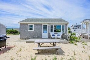 Un charmant chalet situé en bord de mer, doté d’une terrasse, d’un barbecue et d’une table de pique-nique.