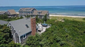 A coastal property with multiple houses, a beach, and a clear view of the ocean. - Beachside Bliss with Skylights & Fireplace (East Sandwich)
