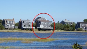 Ein Anwesen am Wasserufer mit mehreren Häusern und einem Steg, wobei ein rotes Rechteck ein bestimmtes Haus hervorhebt.