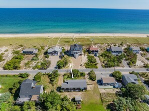 Eine Wohngegend an der Küste mit Häusern, einem Strand und einer Straße.
