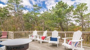 Eine Terrasse mit Adirondack-Stühlen und einem Tisch, auf dem 