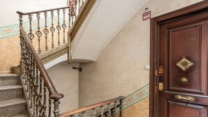 A staircase with ornate balusters, a wooden handrail, and a patterned wall. - AMAZING Gran de Gràcia (08012 Barcelona)