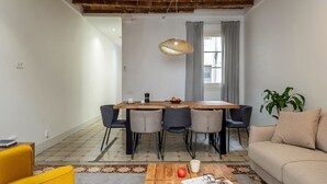 Un espai de vida modern amb zona de menjador, un sofà i una taula de centre.