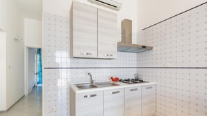 A modern kitchen with white cabinets, a stainless steel sink, and a gas stove. - 2048 Casa Marchello - Bilo 2 by Barbarhouse (Castrignano del Capo)