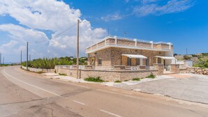 A two-story stone building with a balcony, located beside a curved road. - 2048 Casa Marchello - Bilo 2 by Barbarhouse (Castrignano del Capo)
